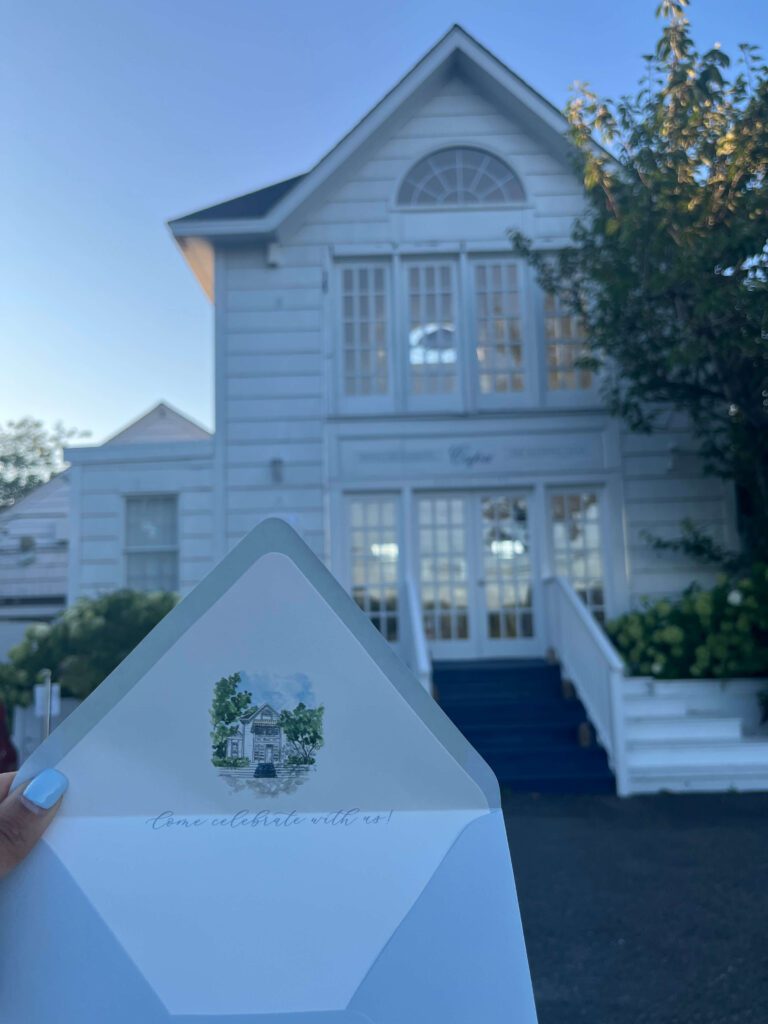 Custom illustrated wedding hotel envelope liner held in front of classic white Hamptons wedding hotel  with coastal architecture Capri